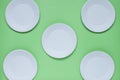 The layout on a green background from paper disposable plates. Caring for the environment. Recycling and sorting of garbage. Royalty Free Stock Photo