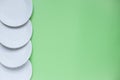 The layout on a green background from paper disposable plates. Caring for the environment. Recycling and sorting of garbage. Royalty Free Stock Photo