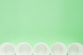 The layout on a green background from white paper disposable cups. Caring for the environment. Recycling garbage Royalty Free Stock Photo