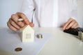 Layout of a house made of white paper and a woman& x27;s hand, a calculator on a white table. The concept of a mortgage. Royalty Free Stock Photo