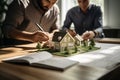 Layout of a house on a table and hands of businessmen, concept of development strategy design. AI-Generated