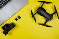 Layout of the modern traveler: Camera,Drone,Memory cards,PC on yellow background