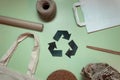 layout of recyclable things on a green background. ecology, concern for recycling. recycling sign in the center Royalty Free Stock Photo