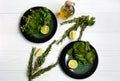 Layout of vegetarian products on two plates with spinach and basil, a bottle of olive oil, rosemary branches and lime Royalty Free Stock Photo