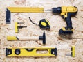 The layout of the yellow tools on the OSB: screwdriver, hammer, level, angle, rutelka, bits.