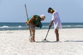 Lazurne, Ukraine - 09.10.2019 Two funny middle-aged women looking for gold on the beach using metal detector