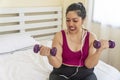 Lazy activity exercise fit body diet or obesity concept. Tired overweight fat woman holding dumbbell in own hands workout Royalty Free Stock Photo