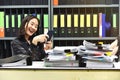 Lazy asian office woman using mobile smart phone in working time. Royalty Free Stock Photo