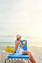 Lazy beachy, summer days. an attractive young woman lounging on the beach and enjoying a cocktail. Royalty Free Stock Photo