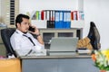 Lazy business man talking on mobile phone with feet on desk in office Royalty Free Stock Photo