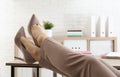 Lazy employee resting at table in office, closeup of legs Royalty Free Stock Photo