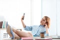 Lazy employee taking selfie at table in office