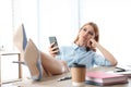 Lazy employee using smartphone while resting at table