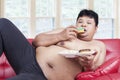 Lazy fat person eating donuts Royalty Free Stock Photo