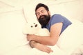 Lazy hipster relax in bedroom. good night and sweet dreams. bearded man teddy bear in bed. plush toy concept. happy Royalty Free Stock Photo