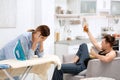 Lazy husband watching TV and his tired wife Royalty Free Stock Photo
