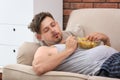 Lazy man with bowl of chips sleeping on sofa Royalty Free Stock Photo