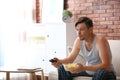 Lazy man with bowl of chips watching Royalty Free Stock Photo