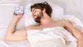 Lazy man happy waking up in the bed rising hands in the morning with fresh feeling relaxed. Man eyes are closed with Royalty Free Stock Photo