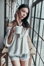 Lazy morning. Attractive young woman holding a cup and looking a Royalty Free Stock Photo