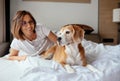 Lazy morning in bed - woman and her beagle dog meet morning Royalty Free Stock Photo