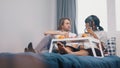 Lazy morning in bed. Young multiethnic couple drinking juice and having a breakfast in the bedroom Royalty Free Stock Photo