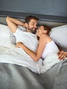 Lazy mornings filled with love. a happy young couple relaxing in bed together at home.