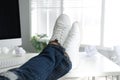 Lazy office employee resting with feet on desk in office