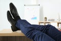 Lazy office employee resting with feet up on desk, closeup