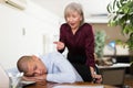 Office employee sleeping at workplace on background of dissatisfied female boss