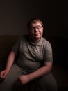 Lazy overweight male sitting on couch and watching something Royalty Free Stock Photo