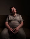 Lazy overweight male sitting on couch and watching something Royalty Free Stock Photo