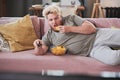 Lazy man eating potato chips and watching TV Royalty Free Stock Photo