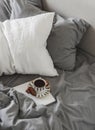 A lazy, unhurried weekend morning. Black coffee, magazine in bed with linen bedding, top view Royalty Free Stock Photo