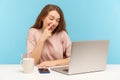 Lazy woman employee picking nose and looking into laptop screen with careless expression, talking on video call