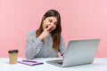 Lazy woman office worker having fun picking nose and looking into laptop screen with careless expression, talking on video call at