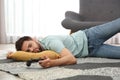 Lazy man playing video game while lying on floor at home