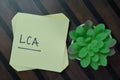 LCA - Life-Cycle Assessment write on sticky notes isolated on Wooden Table