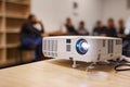 LCD video projector at business conference or lecture in a conference room or office with blurred people background Royalty Free Stock Photo