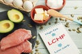 LCHF concept. Notepad with text and dietary food on light table Royalty Free Stock Photo