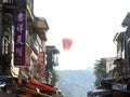 LChinese Sky Lanterns flying up in-between shop houses