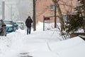 Ld man with cane walking down a snow covered road