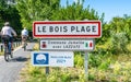 Le Bois Plage town sign and tourists riding a bike on RÃÂ© island France