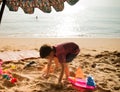 le boy playing sand on the beach summer time