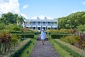 Le Chateau de Bel Ombre Mauritius, old castle in tropical garden in Mauritius, woman walking in a garden of an old
