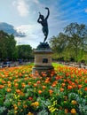 Le faune dansant-Jardin translation The dancing fauna sculptureu in Luxembourg Garden. Beatiful Tulips Paris France