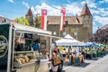 Le Gruyere AOP cheese shop at Bulle market with people and castle in background in Bulle La Gruyere Switzerland