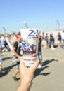 LE MANS, FRANCE - JUNE 18, 2017: A hand holds a plastic glass with beer with a photo of winner's car during race 24 hours