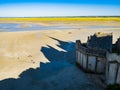 Le Mont Saint Michel, impressive shadow of the famous abbey and tourists walking on the colourful sand flats during low tide, Norm