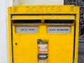 Bright yellow metal postbox from the French National Post with a dedicated compartment for Pas